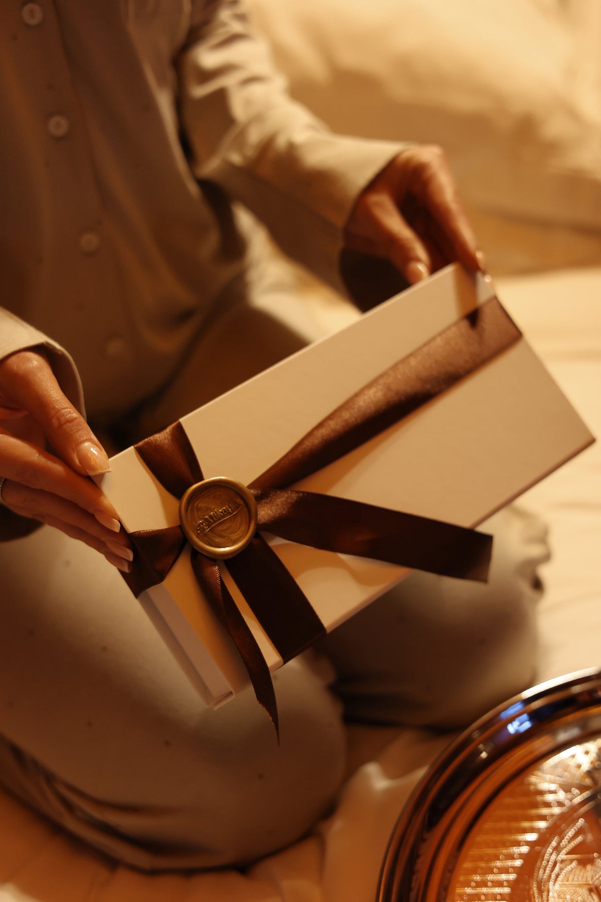 The Silk Sleep Mask gift box, tied with chocolate satin ribbon and a gold By Mikayla wax seal